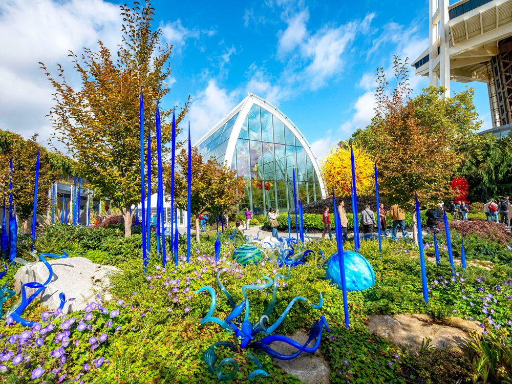 Colorful glass art installations surrounded by flowers at Seattle's Chihuly Garden and Glass