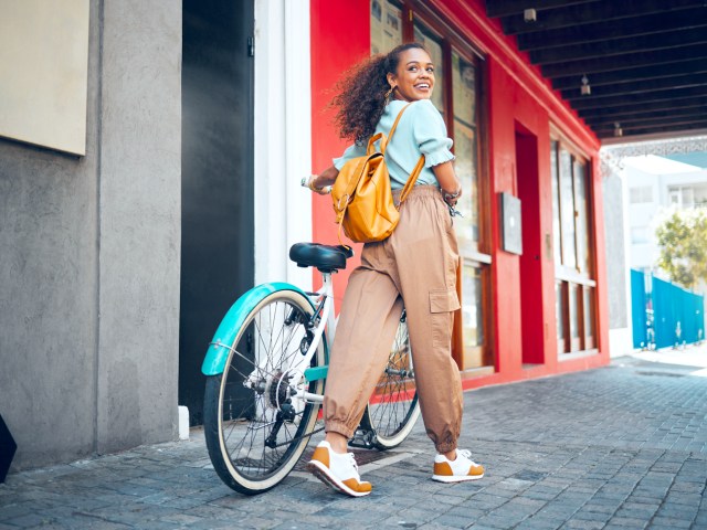 Person walking with bicycle and looking back