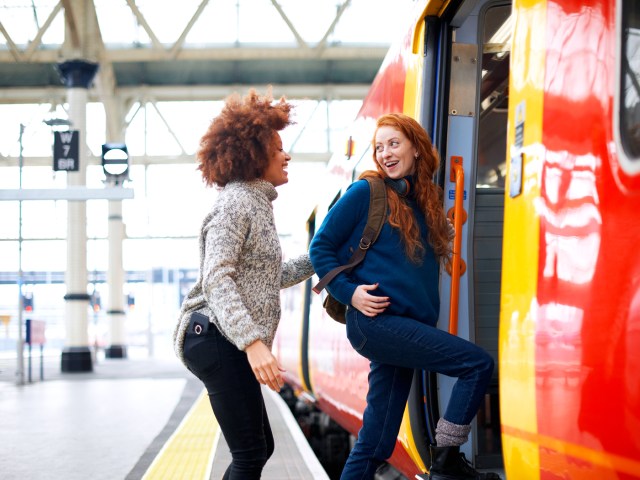 Pair of travelers boarding train in station