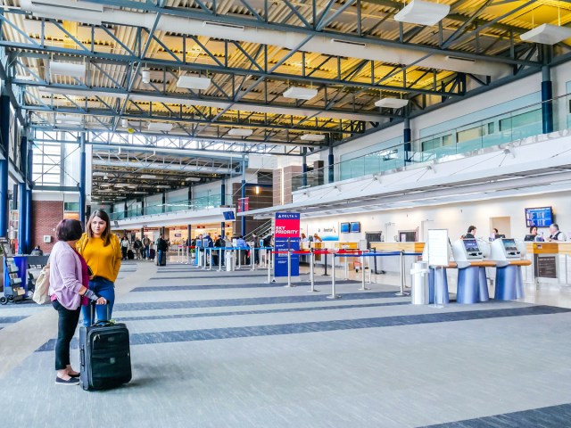 Pair of travelers standing in check-in area of Northwest Arkansas National Airport