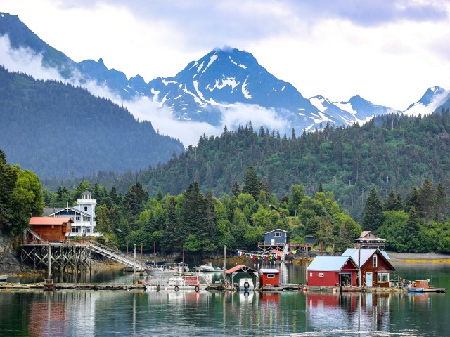 Alaskan seaside village with mountains and forest in background