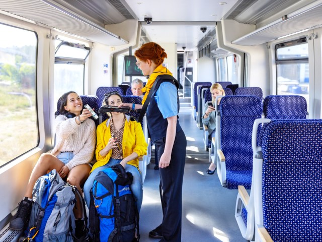 Staff member checking tickets on train