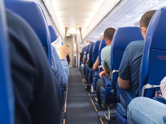 View of aircraft cabin aisle from back to front