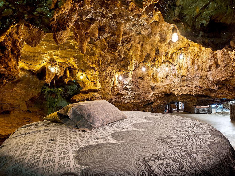 Bed under cave ceiling at Beckham Creek Cave Lodge in Parthenon, Arkansas