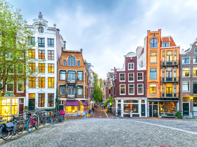 Cobblestone bridge lined with traditional dutch homes in Amsterdam, the Netherlands