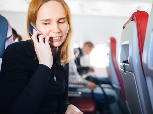 Passenger talking on cell phone on airplane