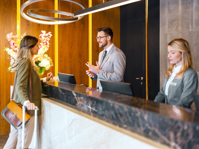 Hotel guest speaking with front desk staff