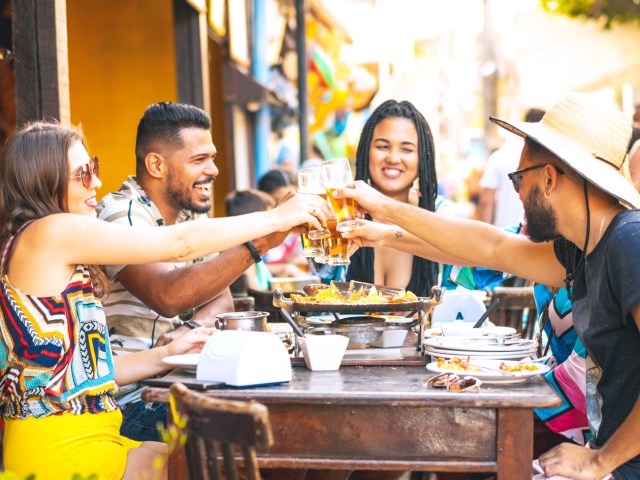 Group of diners toasting with beer glasses