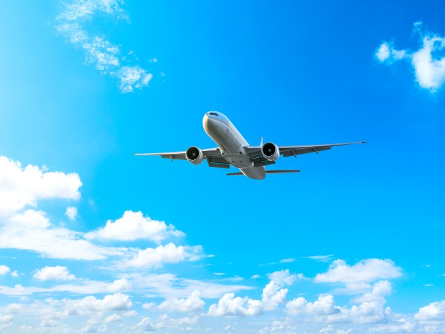 Airplane flying through partly cloudy sky