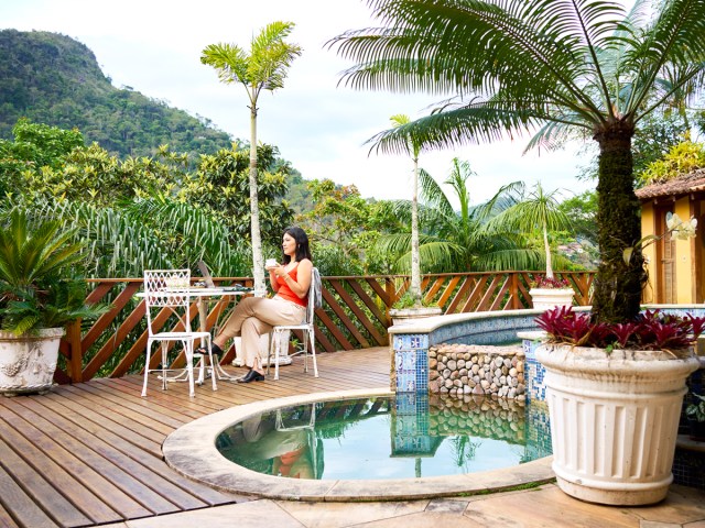 Woman relaxing next to small pool looking out at mountains