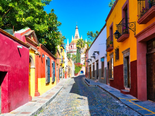 Narrow street lined with brightly painted homes in San Miguel de Allende, Mexico