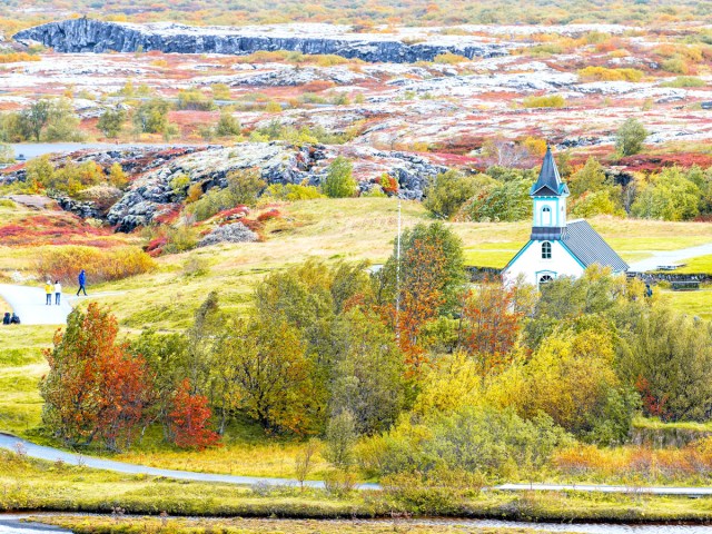 Aerial view of church surrounded by fall foliage in Iceland