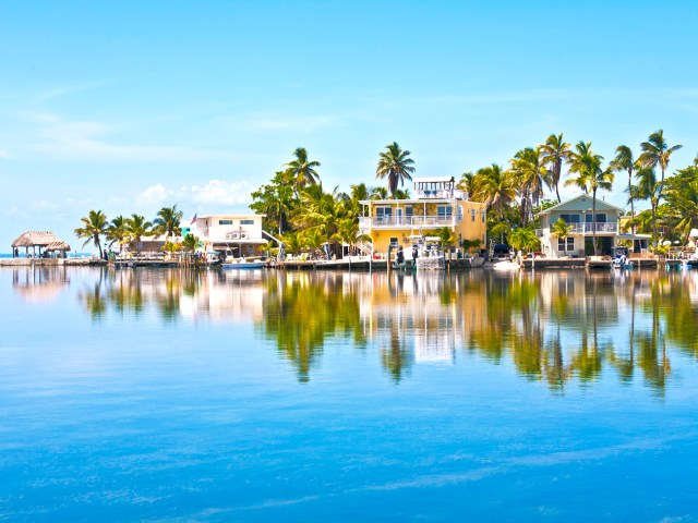 Homes and palm trees reflecting on water in the Florida Keys