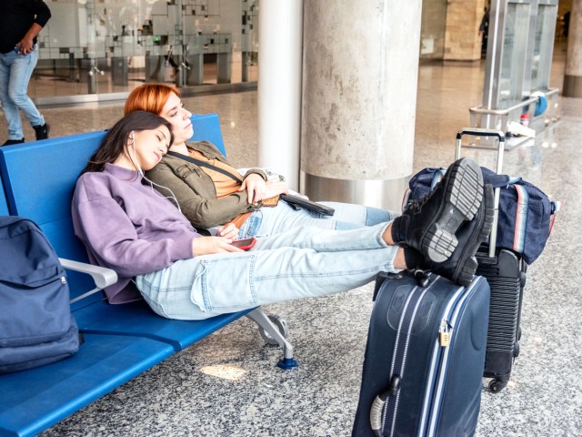 Pair of travelers resting on airport seats