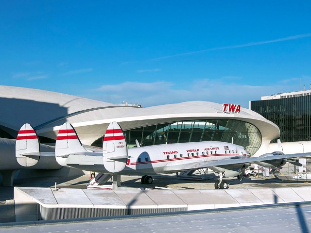 Vintage airplane parked outside of former TWA terminal, now hotel, at New York John F. Kennedy International Airport