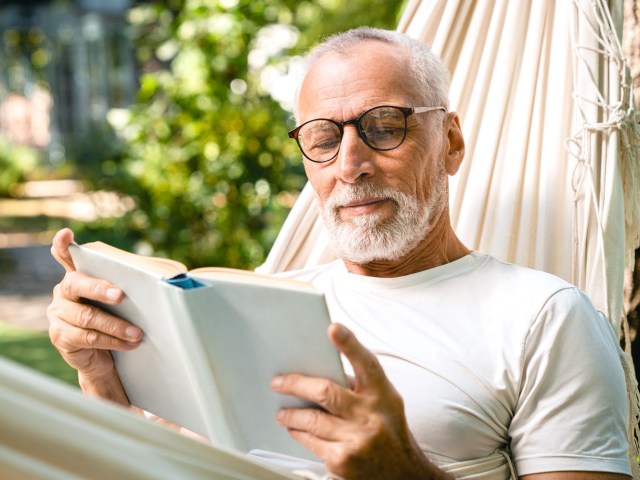 Person reading book in hammock