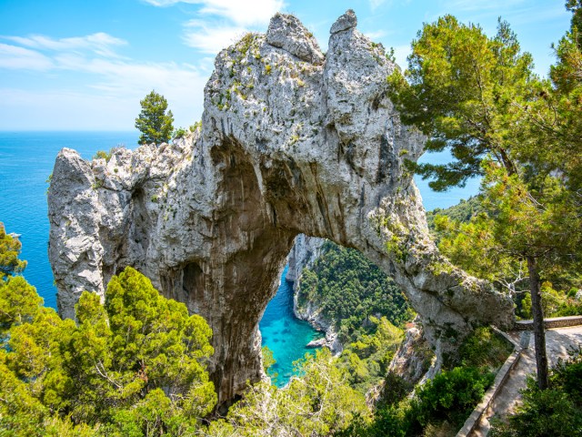 Arco Naturale rock arch perched over coast of Capri, Italy