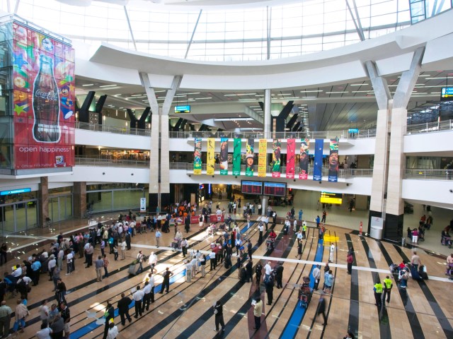 Passengers inside light-filled interior of Johannesburg’s O.R. Tambo International Airport in South Africa