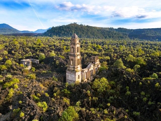 Aerial view of Church of Viejo San Juan Parangaricutiro surrounded by forest in Mexico