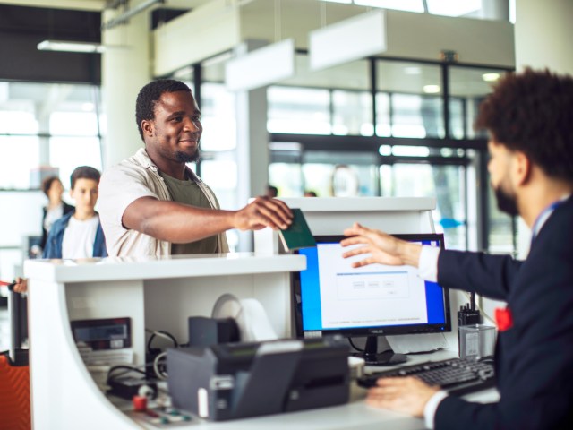 Airline passenger handing agent passport at check-in desk