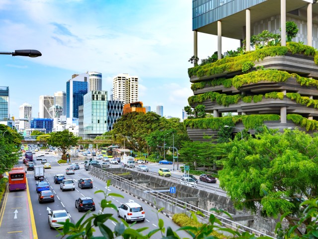 Busy highway next to building covered in greenery in Singapore