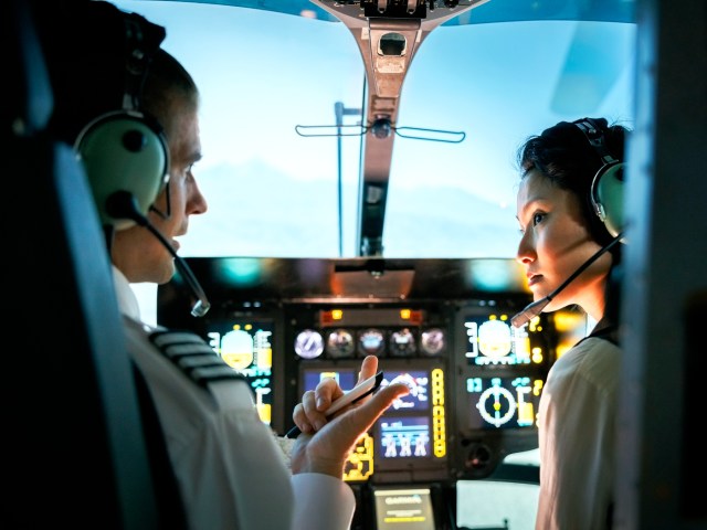 Pilot and co-pilot communicating in aircraft cockpit