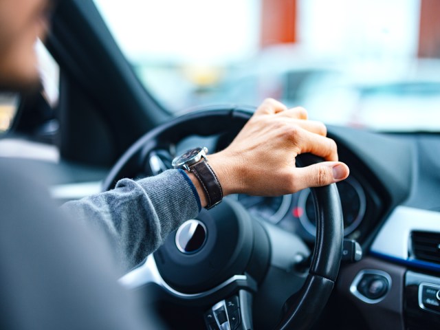 Close-up image of driver's hand on steering wheel