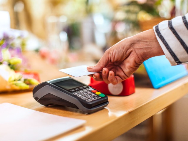 Customer using tap-to-pay on credit card machine in store