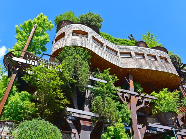 View from street level up at Condominio 25 Verde complex interspersed with trees in Turin, Italy
