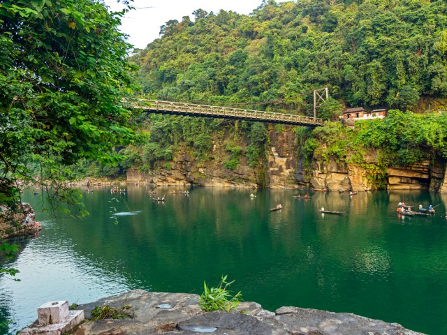 Rowboats under bridge in river in Cherrapunji, India