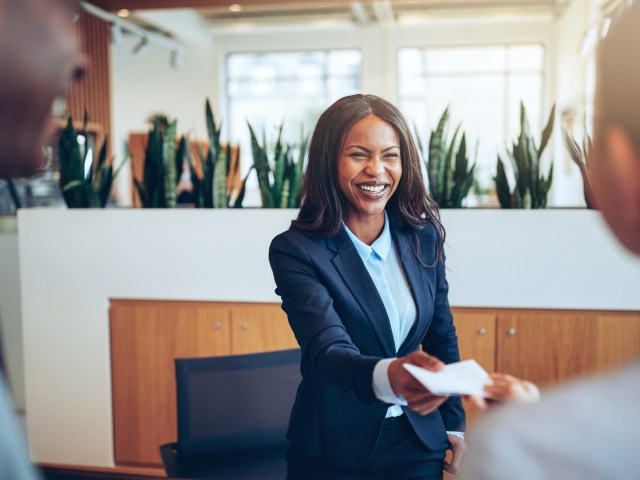 Hotel front desk receptionist handing customer folio