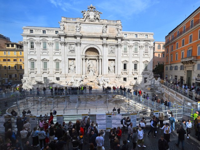 Tourists surrounding scaffolding over the Trevi Fountain as renovations are underway