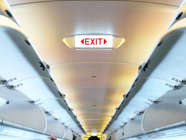 Illuminated exit sign on ceiling of aircraft