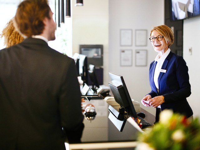 Guests interacting with hotel front desk agent