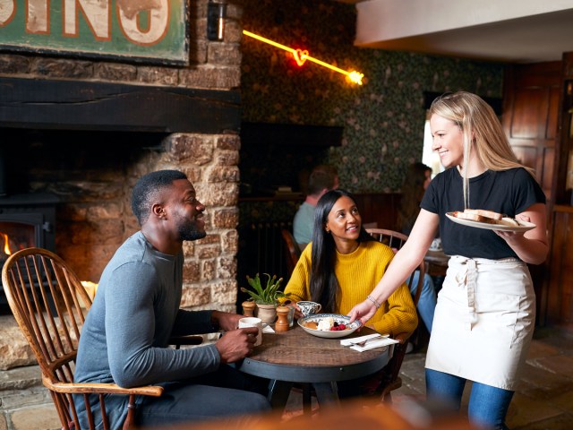 Diners interacting with server at restaurant