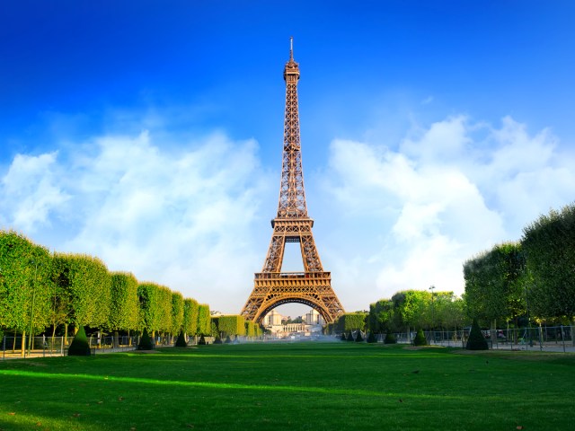 Eiffel Tower seen across grassy field in Paris, France