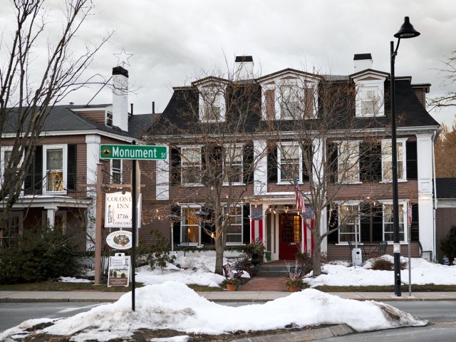 Snowy sidewalks and exterior of Concord Colonial Inn in Concord, Massachusetts