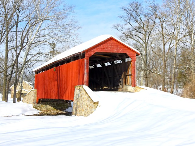 Red covered bridge in snowy landscape of Pennsylvania