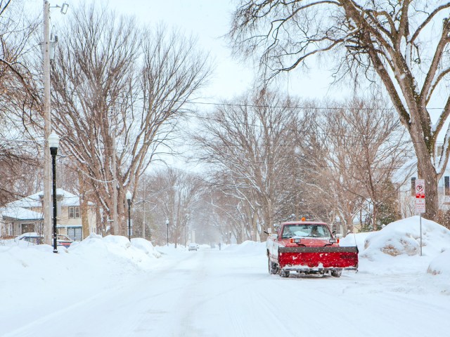 Snow plow on snow-covered road in Fargo, North Dakota