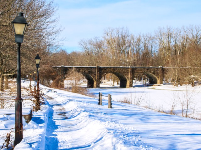 Snowy path toward stone bridge in Connecticut