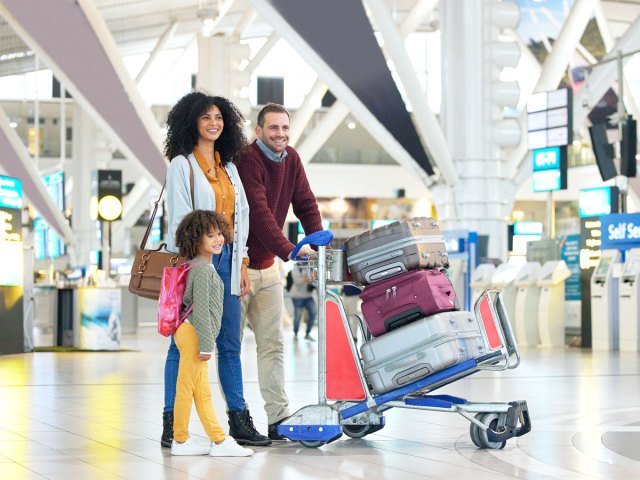 Family walking through airport with suitcases