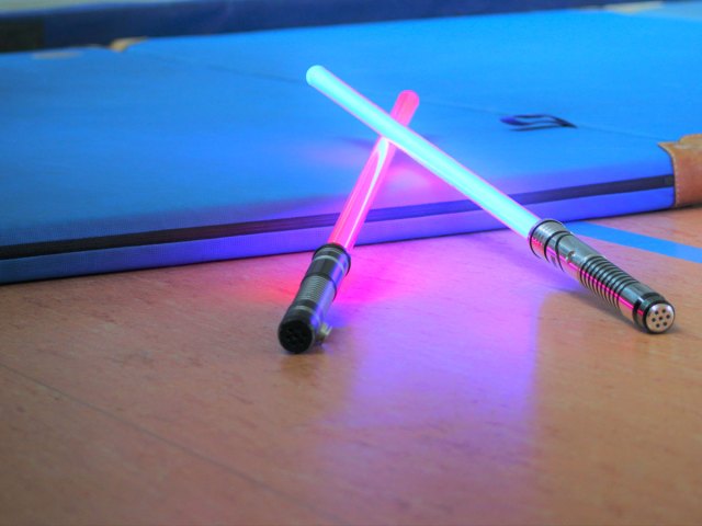 Two toy lightsabers crossed on a table