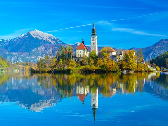 Church on small island in Lake Bled, Slovenia, with reflection on water's surface