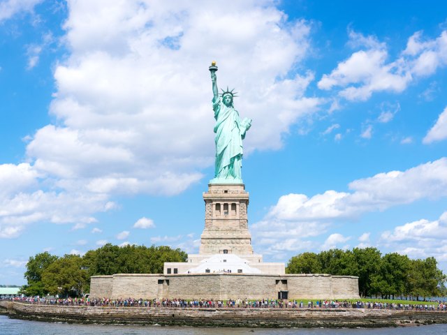 Tourists gazing up at the Statue of Liberty in New York Harbor