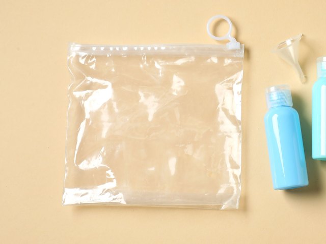 Clear plastic bag and small reusable toiletry bottle on table