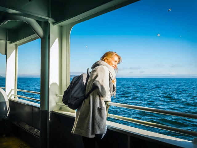 Woman gazing into the sea from cruise ship balcony