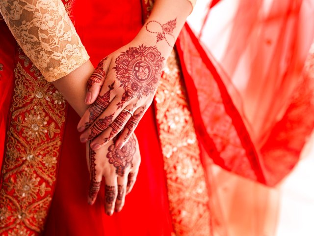 Close-up image of traditional red Mehndi on wedding guest