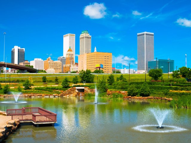 Pond with fountains and Tulsa skyline in background