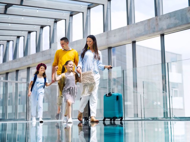 Family walking through airport with luggage