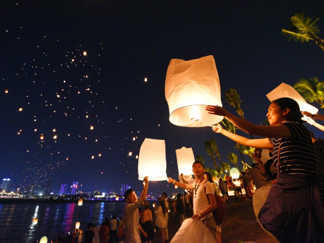 Revelers setting off lanterns into the night sky